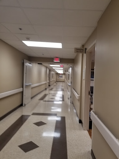 A quiet hallway in a hospital, featuring clean lines and neutral tones.