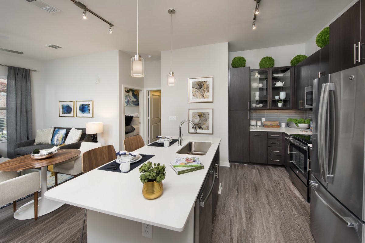A modern kitchen featuring a central island with pendant lighting, contemporary appliances, and stylish decor.