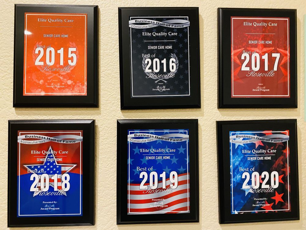 A collection of award plaques from the years 2015 to 2020 displayed on a wall.