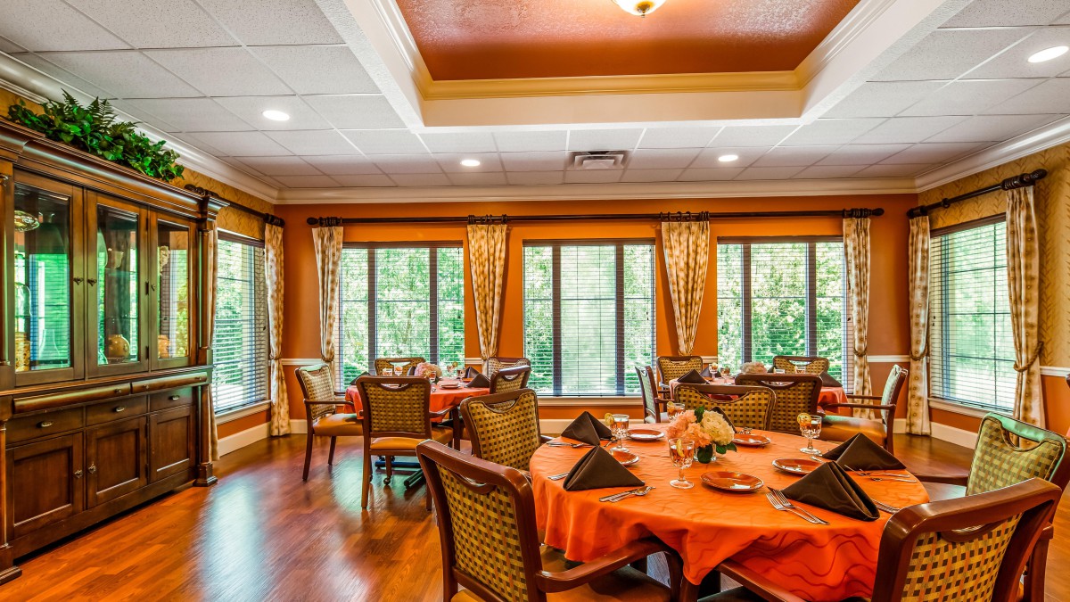 A beautifully decorated dining room with multiple set tables and large windows.