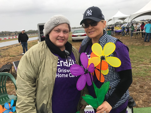 Participants enjoying a community event, showing support with colorful flowers.