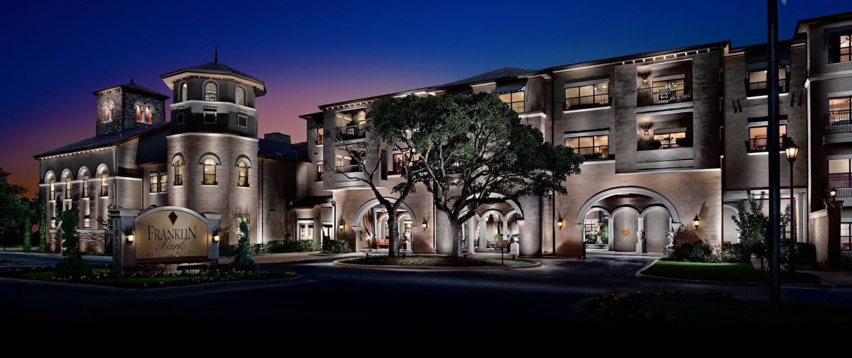 A beautifully lit building at night, surrounded by trees.