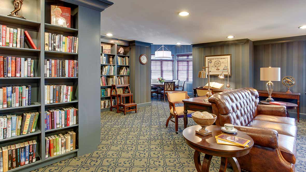 A cozy library with shelves full of books and comfortable seating areas.
