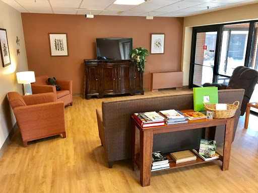 A cozy waiting room featuring comfortable seating, a television, and a selection of magazines.
