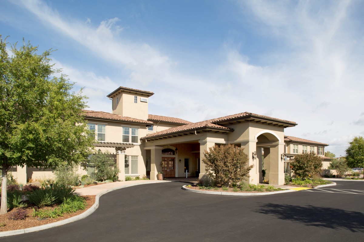 A large residential home with a spacious driveway and landscaped surroundings.