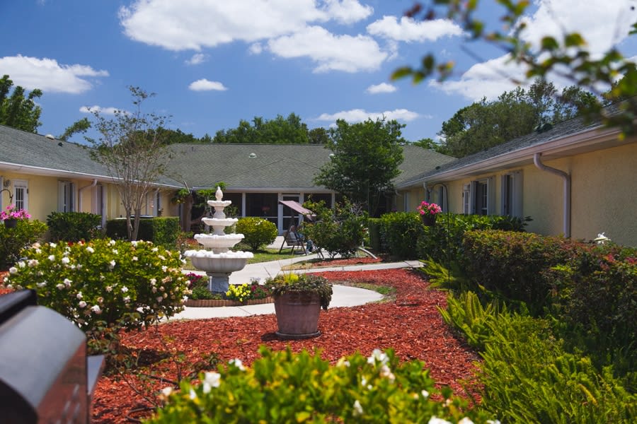 A beautifully landscaped courtyard with a central fountain and vibrant greenery.