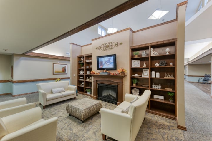 A cozy living room with a fireplace, bookshelves, and comfortable seating.
