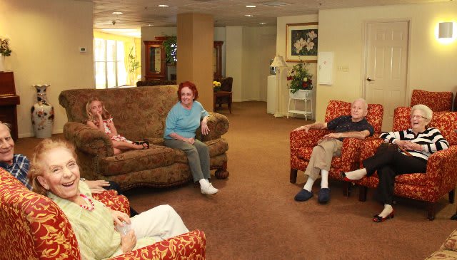 A group of seniors sitting in a comfortable lounge area and socializing.