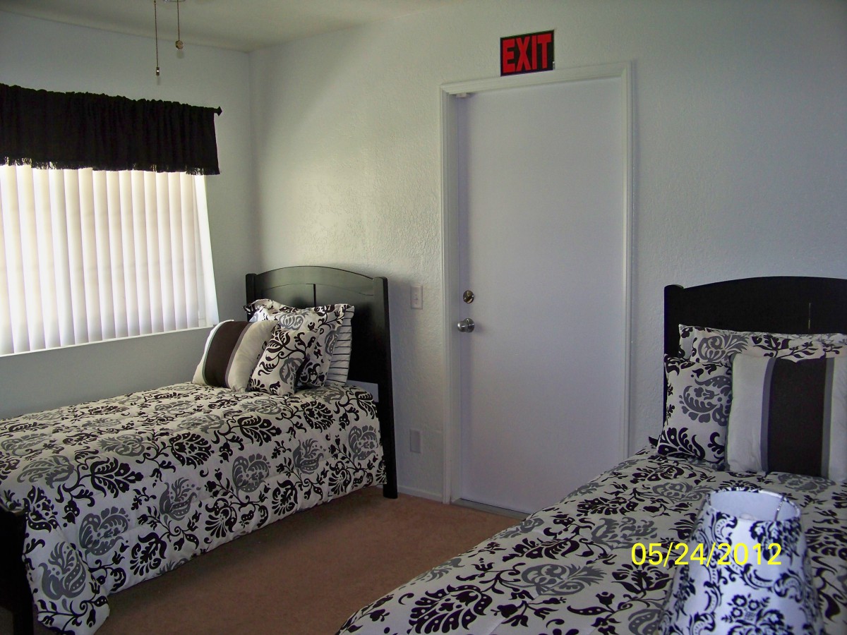 A bedroom with two twin beds featuring black and white patterned bedding.