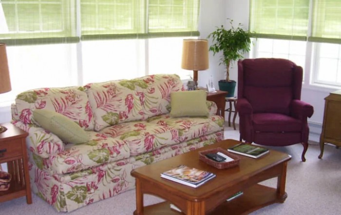 A cozy living room with a floral patterned sofa and a wooden coffee table.