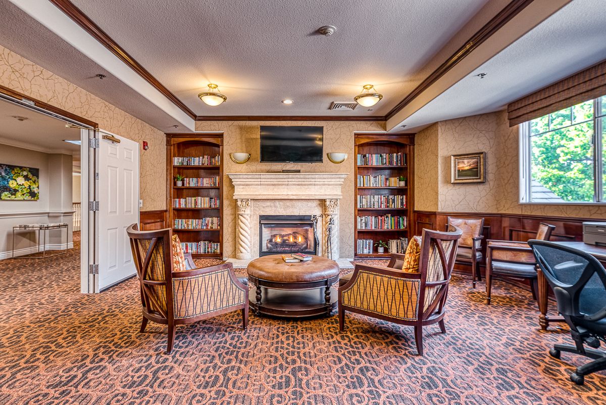 A cozy library with a fireplace and comfortable seating area.