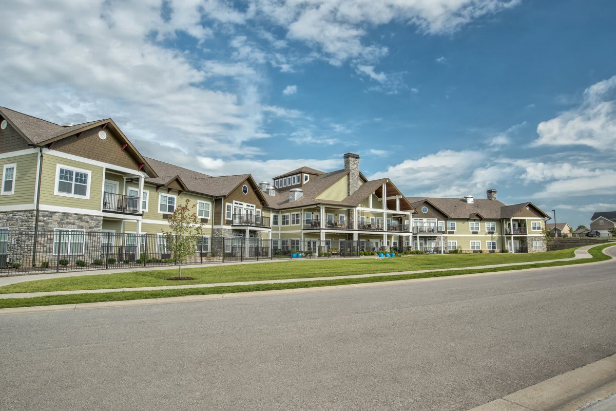 A large residential building with a clear sky and road in the foreground.