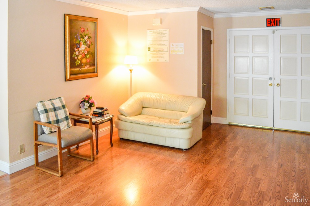 A cozy living room with a sofa, lamp, and a decorative painting on the wall.