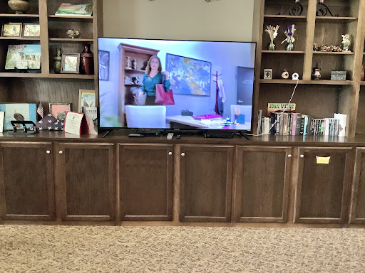 A cozy living room featuring a television display and wooden cabinetry.