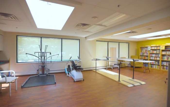 A spacious gym area with exercise equipment and natural lighting.
