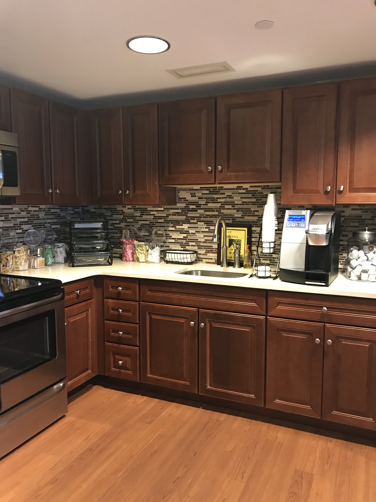 A modern kitchen with wooden cabinets and various appliances.