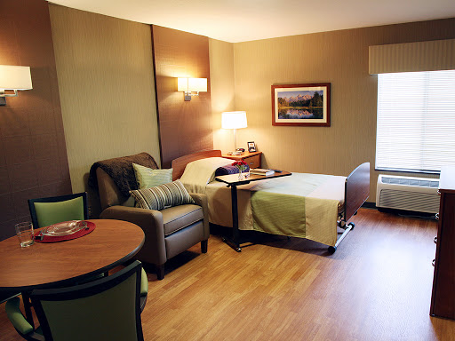 A cozy hotel room featuring a bed, seating area, and modern decor.