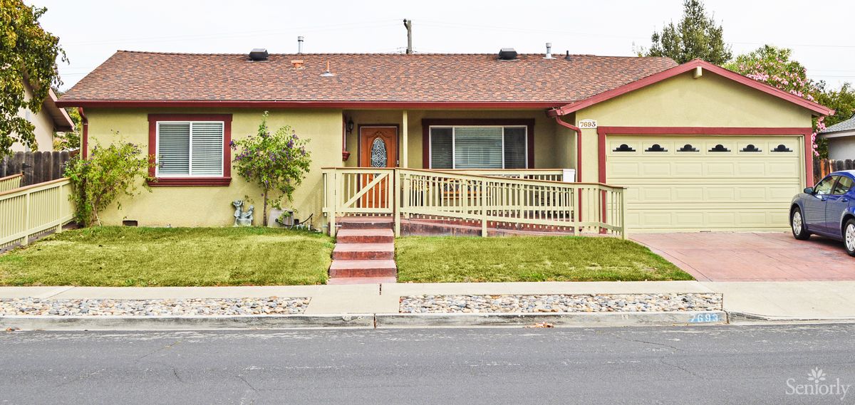 A single-story ranch-style house with a porch and a well-maintained front yard.