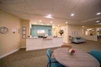 A modern reception area featuring a desk, comfortable seating, and warm lighting.