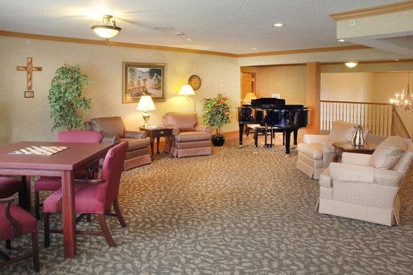 A cozy living room with a grand piano and comfortable seating.
