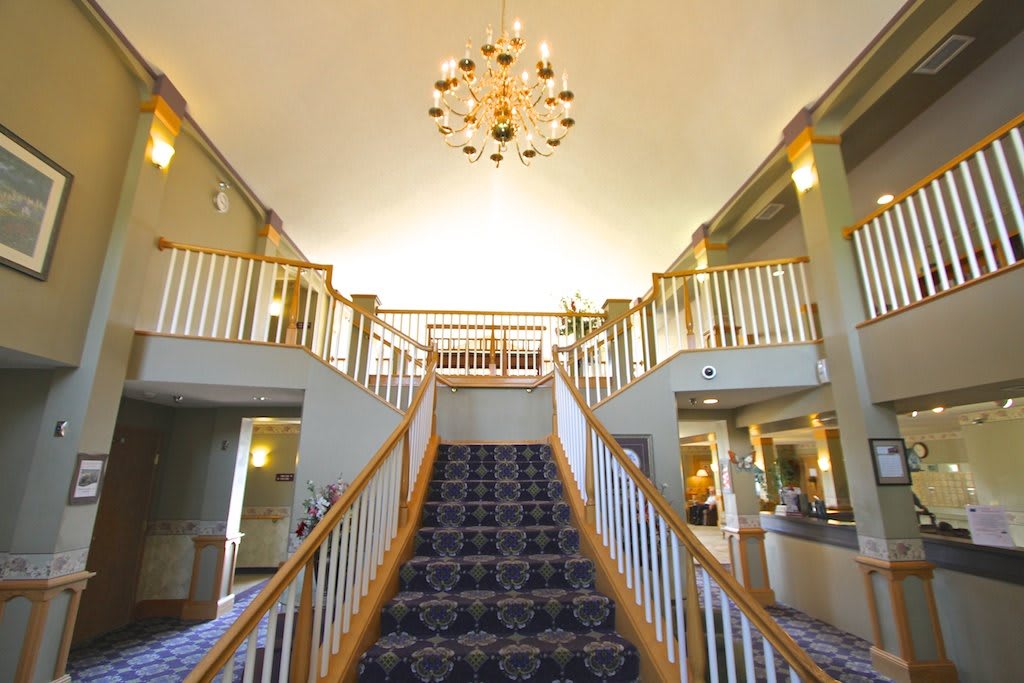 Elegant hotel lobby featuring a grand staircase and chandelier.