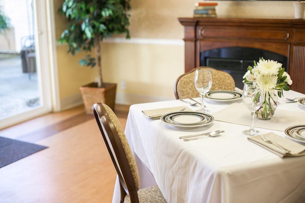 An elegantly set dining table in a restaurant with fine china and glassware.