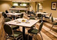 A well-organized conference room featuring tables and chairs, ready for a meeting.