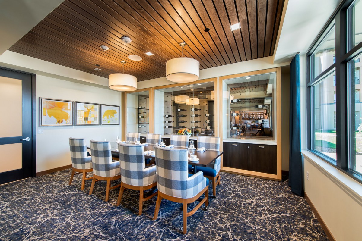 A luxurious dining room featuring a wine cellar and modern decor.