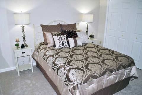 A stylishly decorated bedroom with patterned bedding and elegant lamps.