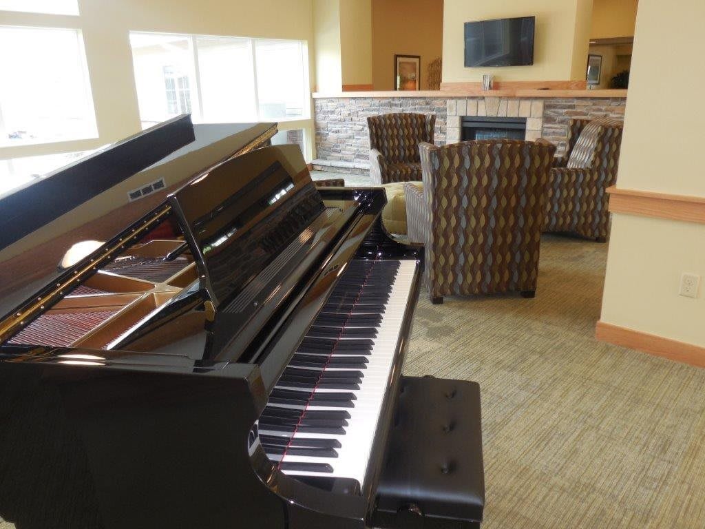 A cozy living room featuring a grand piano and comfortable seating.