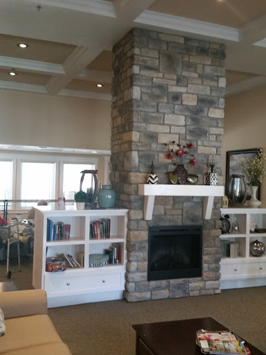 A cozy living room featuring a stone fireplace and stylish bookshelves.