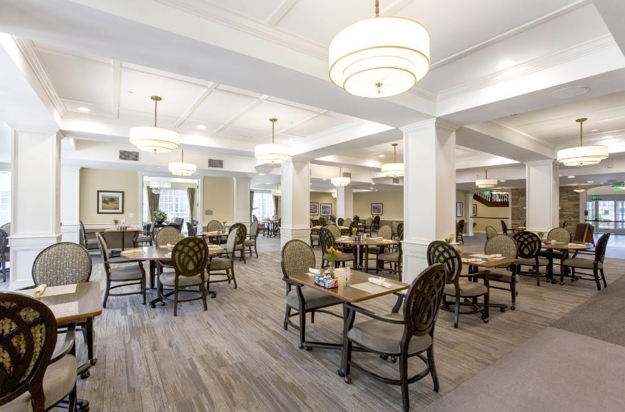 Spacious dining area with multiple tables, elegant lighting, and neutral decor.