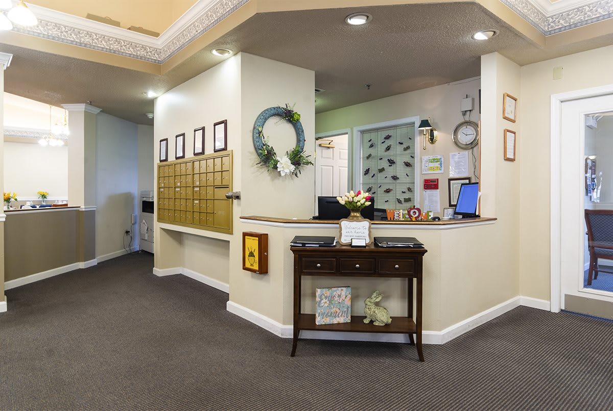 A welcoming reception area featuring a decorative wreath, mailboxes, and a neatly organized desk.