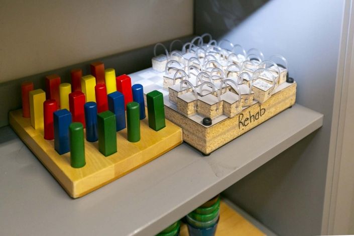 A shelf displaying colorful educational toys, including wooden pegs and clear plastic containers.