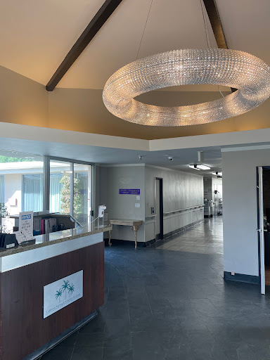 A bright and modern hospital reception area with a stylish chandelier.