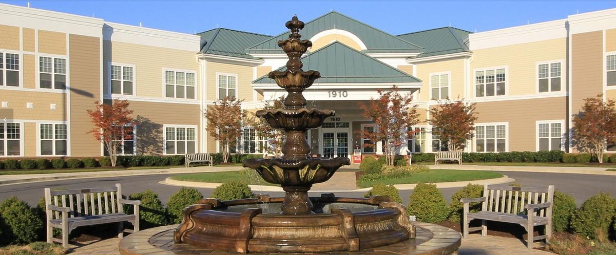 A decorative fountain in front of a modern building.