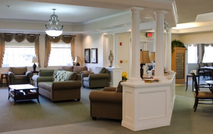 A spacious living room with elegant furniture and decorative pillars.