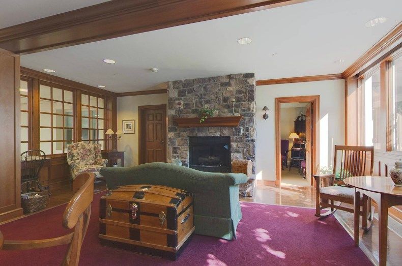 A cozy living room featuring a stone fireplace and comfortable seating.