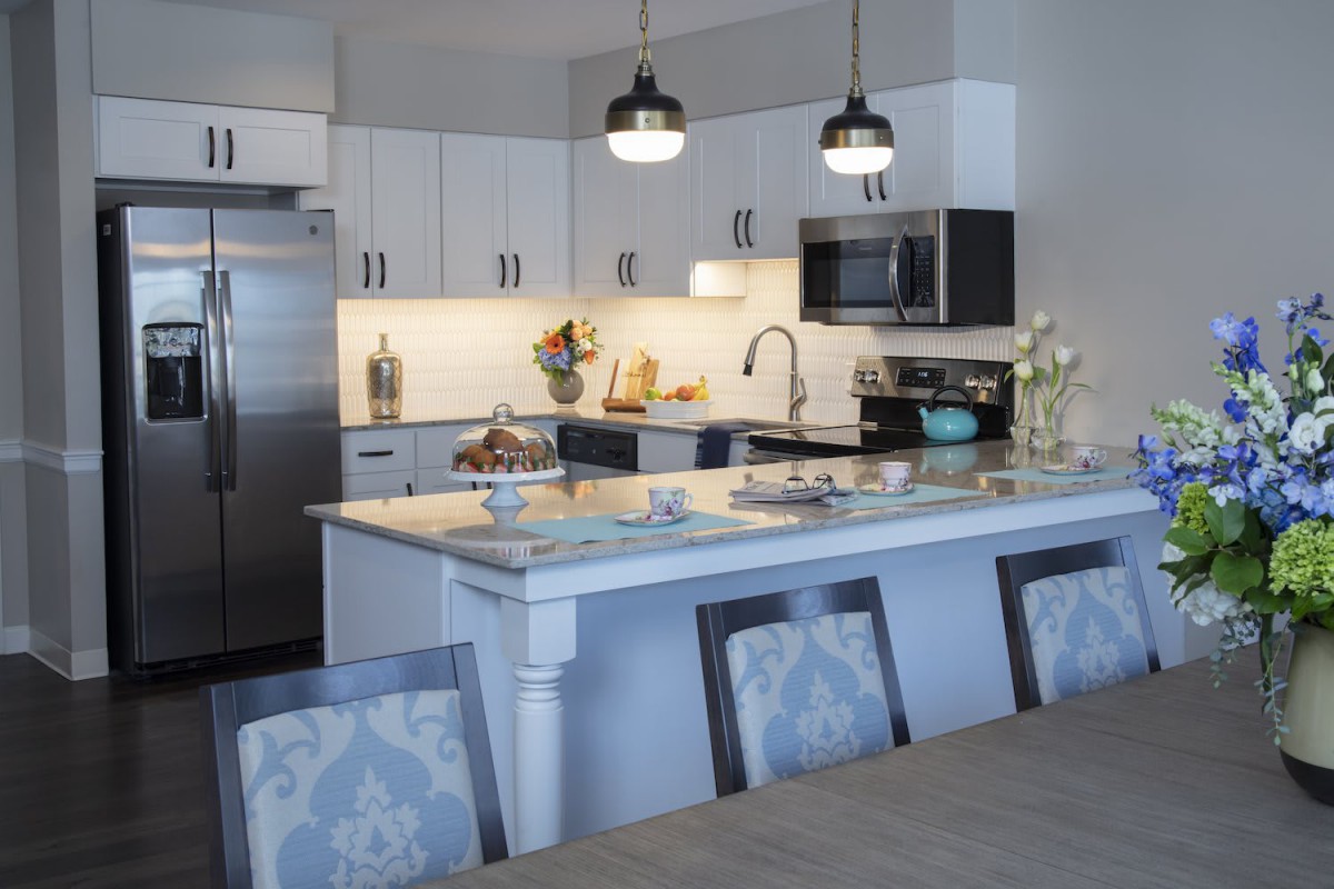 A modern kitchen featuring a spacious island with pendant lighting and contemporary appliances.