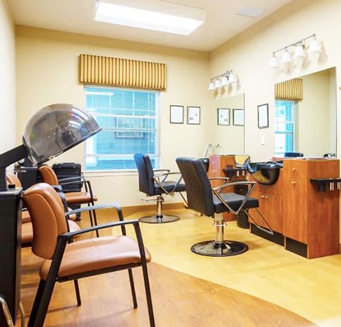 A tidy and well-lit hair salon interior with chairs, mirrors, and a hair dryer.