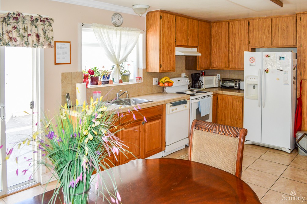 A cozy kitchen and dining area featuring wooden cabinets, a table with chairs, and various appliances.