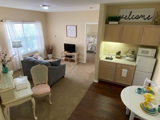 A cozy apartment with a living room, kitchenette, and bedroom in view.