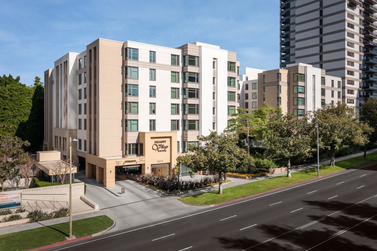 A modern hotel building located on a city street, featuring contemporary architectural design.