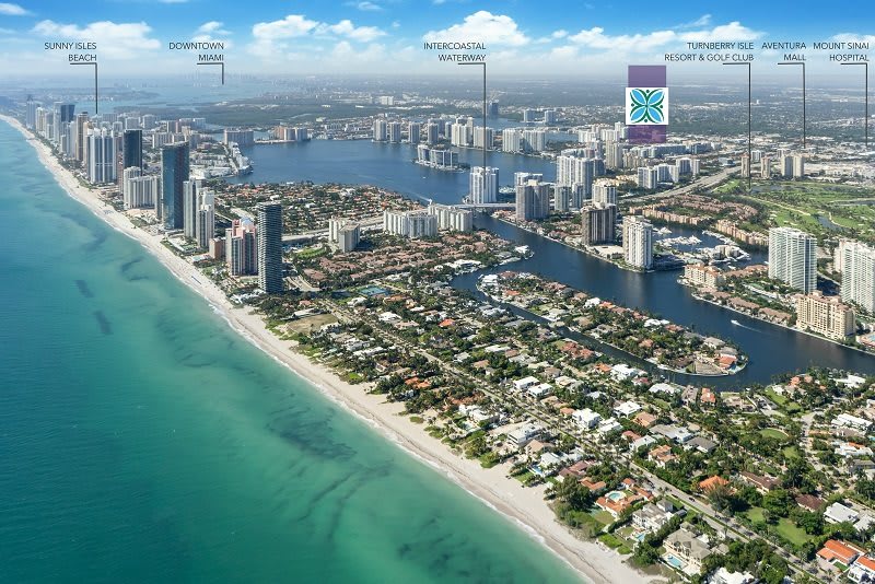 Aerial view of a coastal city with a prominent beachfront and numerous high-rise buildings.