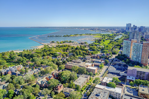 A scenic aerial view showcasing the lush green spaces adjacent to a tranquil lake and vibrant urban surroundings.