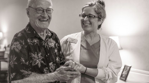 A joyful moment shared between an elderly man and his caregiver, showcasing warmth and connection.