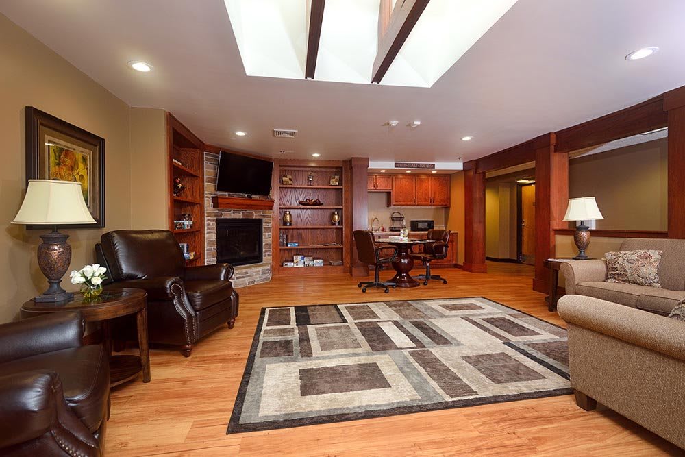 A modern living room with wood flooring, featuring a cozy fireplace and integrated shelving.