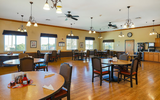 A spacious dining area designed for communal gatherings, featuring tables and chairs arranged for dining.