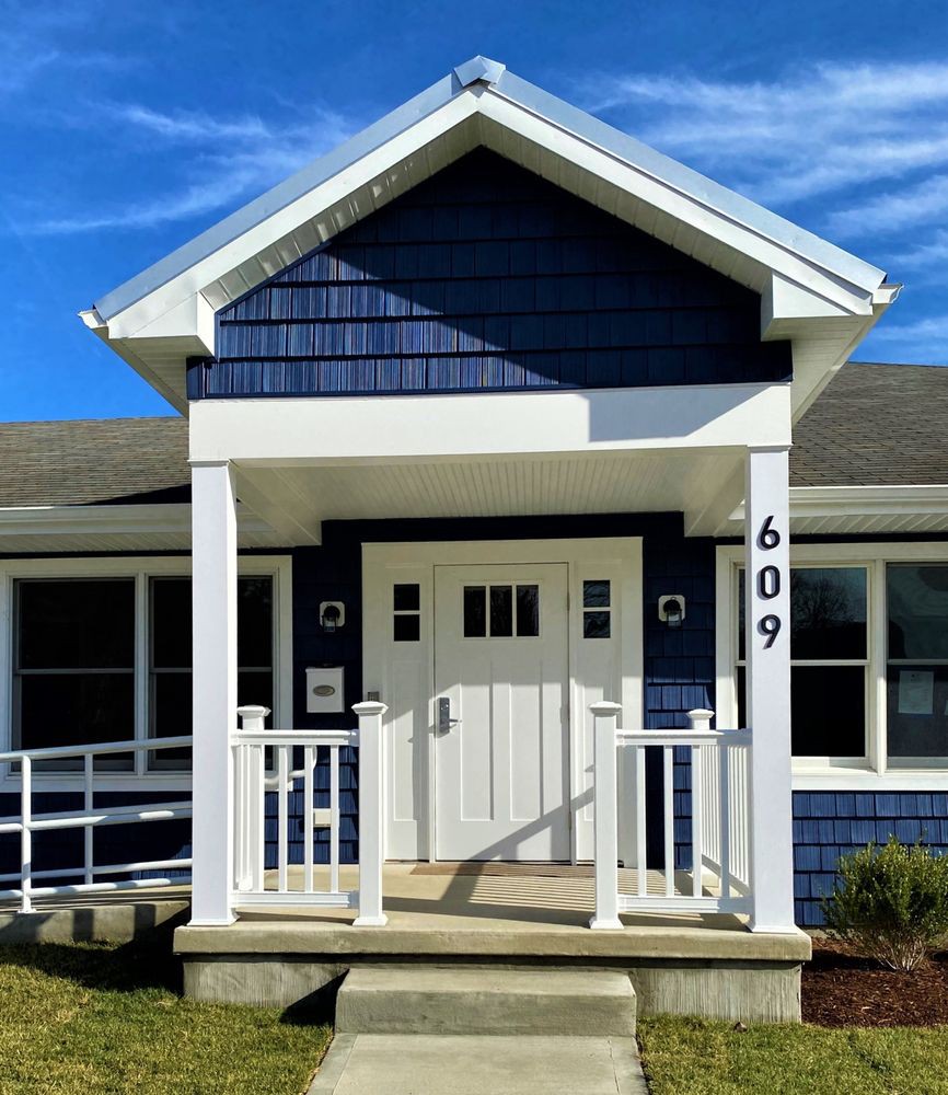 A charming blue house with a small porch and white accents.