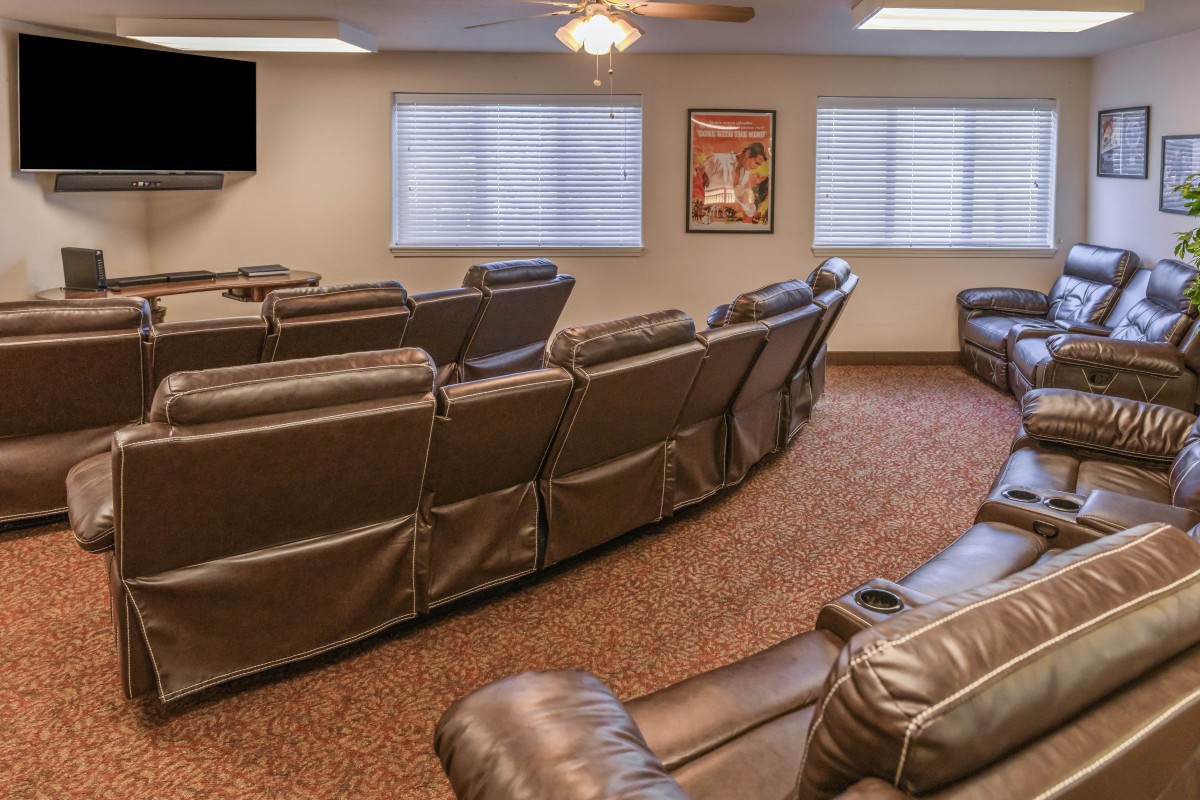 A cozy home theater with multiple recliners facing a large TV.
